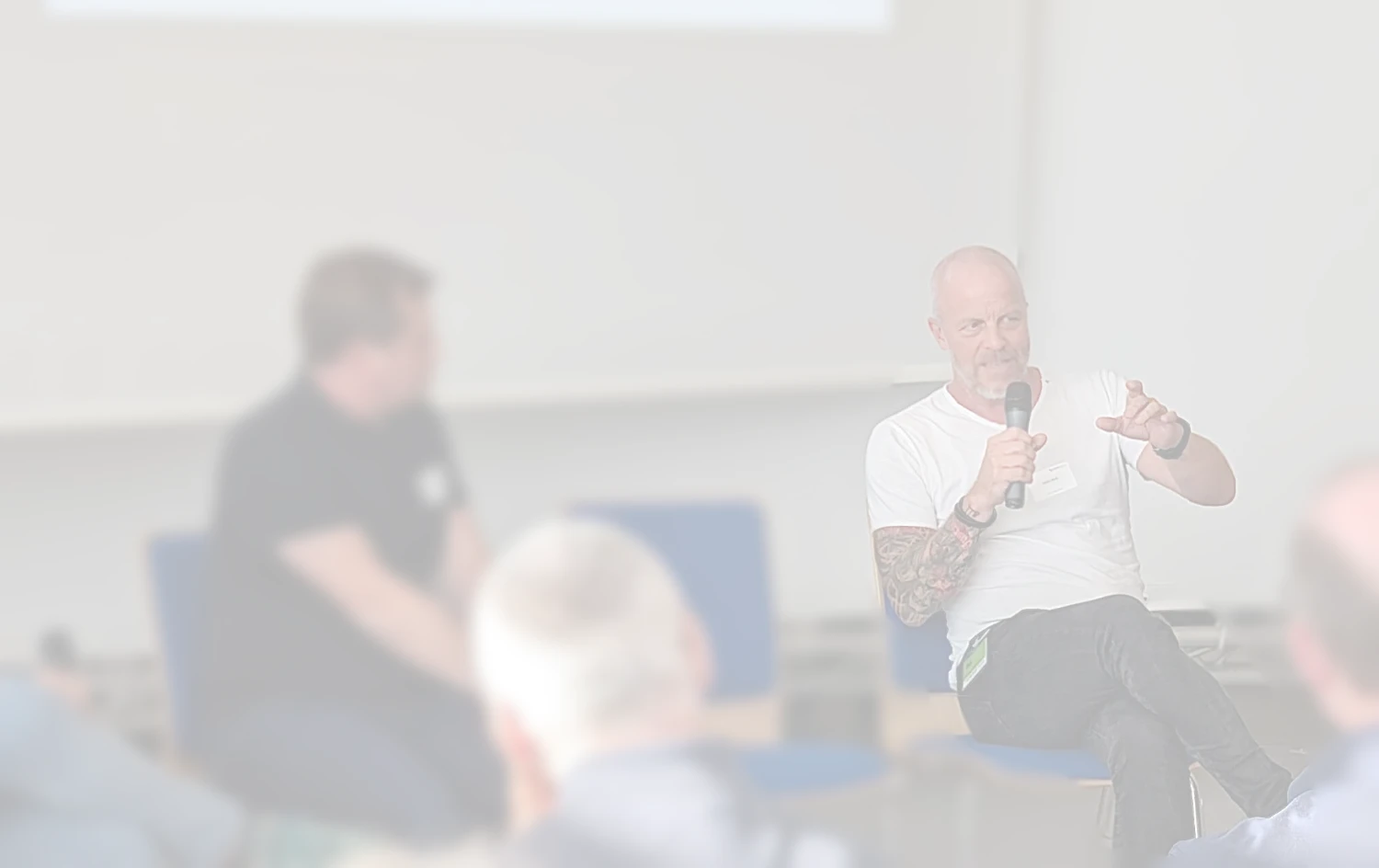 Stefan Kirch spricht in ein Mikrofon vor einem Publikum