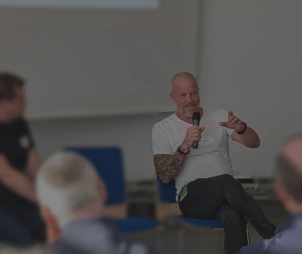 Stefan Kirch spricht in ein Mikrofon vor einem Publikum