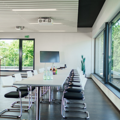 Blockbestuhlung, bei der sich die Personen an einem Tisch gegenübersitzen. Getränke stehen auf dem Tisch.